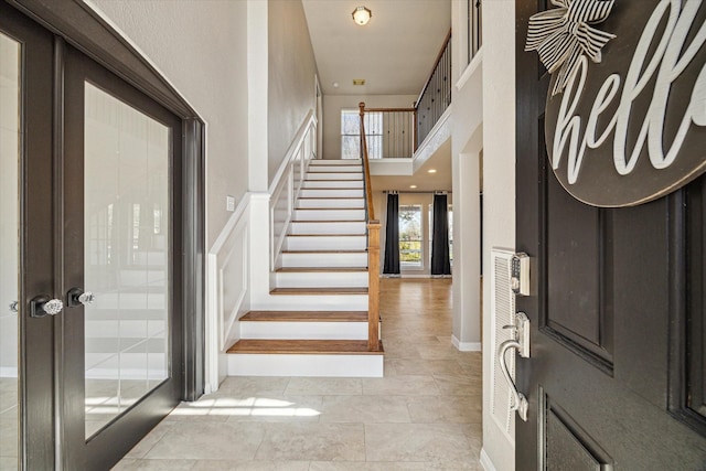 entryway featuring a high ceiling and stairway