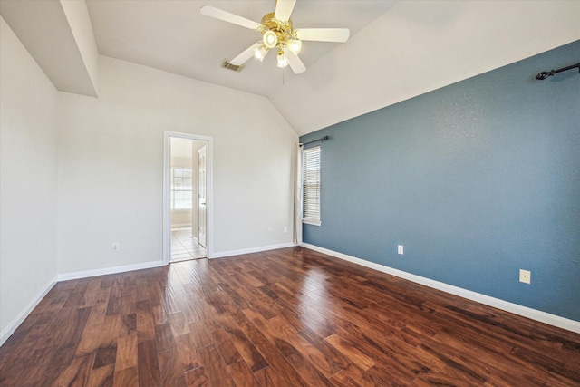 empty room featuring ceiling fan, wood finished floors, visible vents, baseboards, and vaulted ceiling