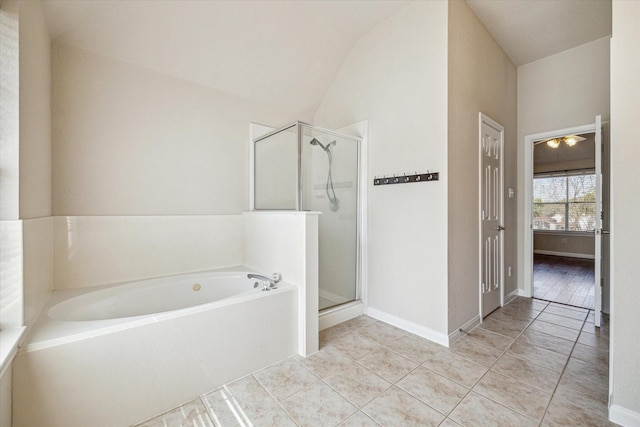 full bathroom with lofted ceiling, a shower stall, tile patterned flooring, baseboards, and a bath