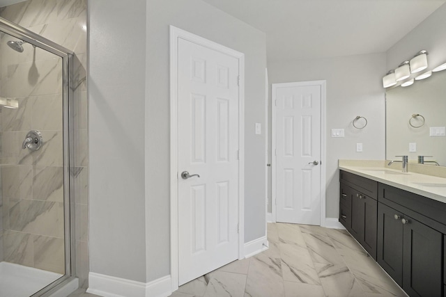 full bathroom with marble finish floor, vanity, baseboards, and a stall shower