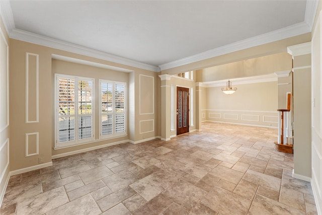 spare room featuring stone finish floor, ornamental molding, a decorative wall, and a chandelier