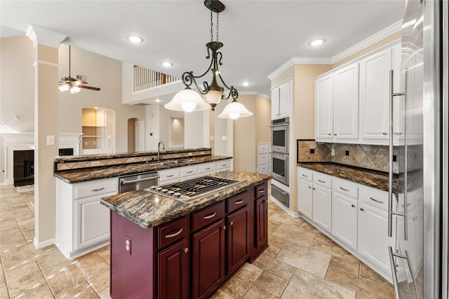 kitchen with stainless steel appliances, a center island, a ceiling fan, ornamental molding, and decorative backsplash