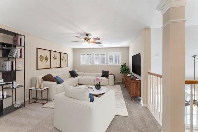 living room featuring light colored carpet, ceiling fan, and baseboards