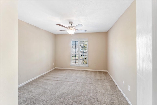 empty room with a textured ceiling, carpet floors, a ceiling fan, and baseboards