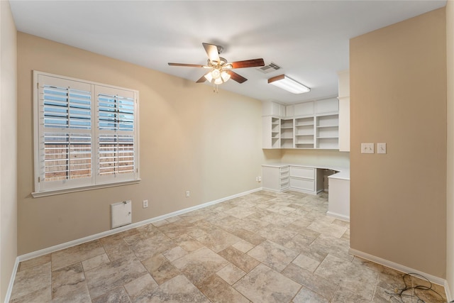 unfurnished office with a ceiling fan, baseboards, visible vents, and built in desk