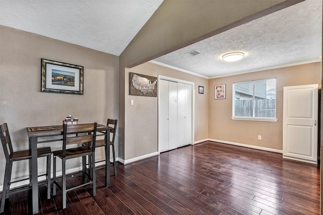 interior space with wood-type flooring, a textured ceiling, visible vents, and baseboards