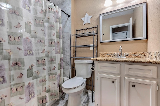 bathroom with curtained shower, a textured wall, vanity, and toilet