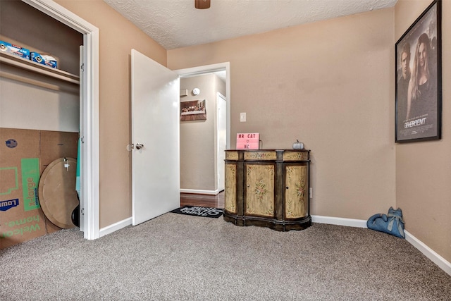 carpeted bedroom featuring ceiling fan, a textured ceiling, and baseboards