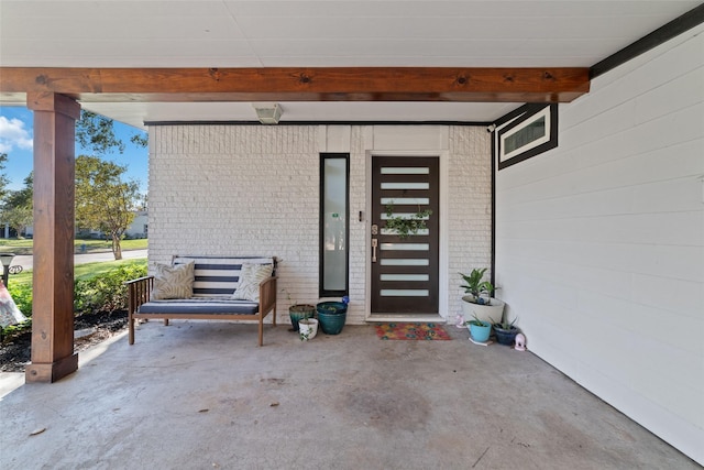 entrance to property featuring brick siding