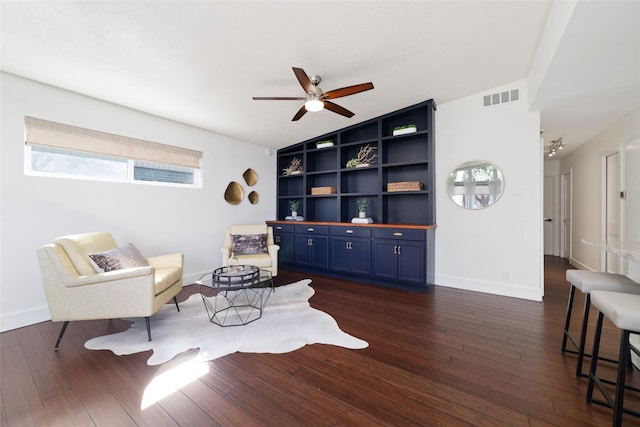 living area featuring dark wood-style floors, visible vents, built in shelves, and baseboards