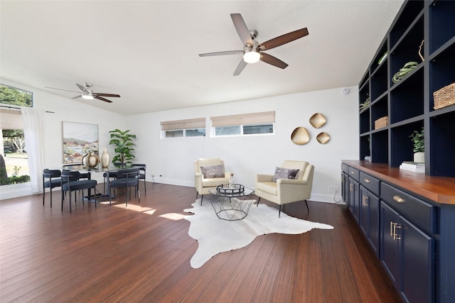 living area with ceiling fan, dark wood-type flooring, baseboards, and vaulted ceiling