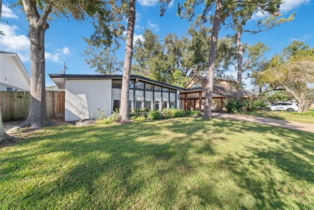 back of property featuring a yard, brick siding, and fence