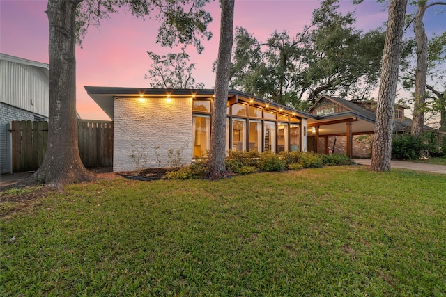 back of property with a yard and fence