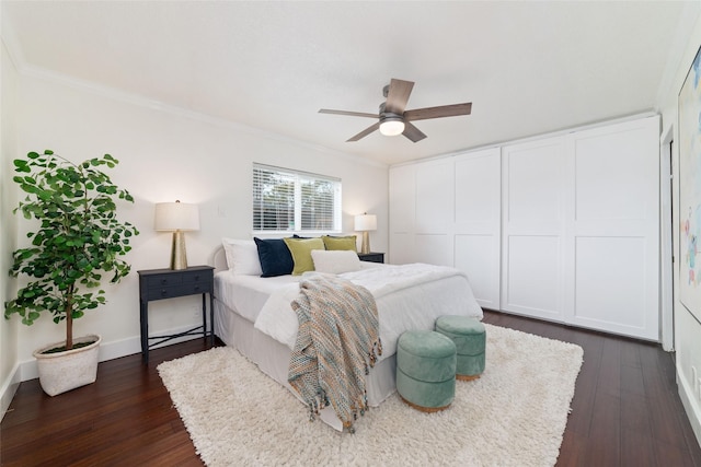 bedroom featuring ceiling fan, baseboards, dark wood finished floors, and crown molding