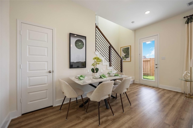 dining room featuring baseboards, visible vents, wood finished floors, stairs, and recessed lighting