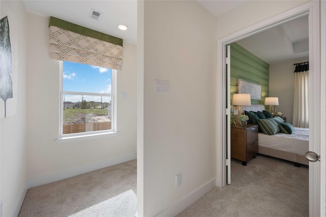 hall featuring carpet flooring, visible vents, and baseboards