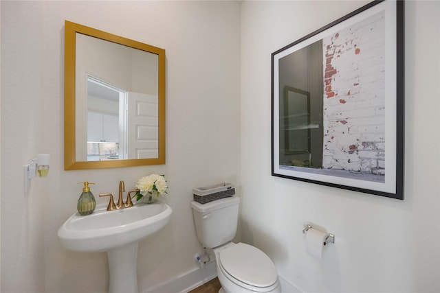 bathroom featuring toilet and baseboards