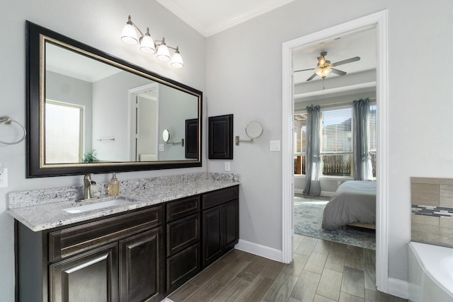 ensuite bathroom with a bathing tub, vanity, baseboards, ornamental molding, and wood tiled floor