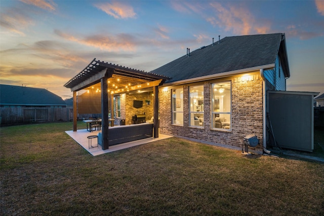 back of house featuring a yard, a patio area, fence, a pergola, and stone siding