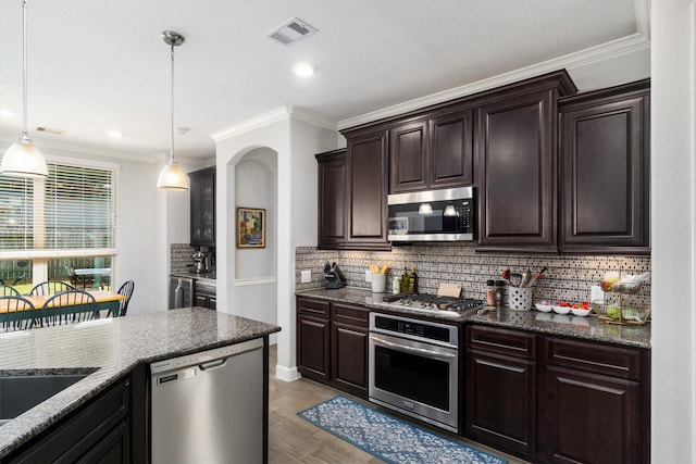 kitchen featuring stainless steel appliances, wood finished floors, visible vents, and crown molding