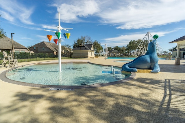 view of swimming pool with a water slide and fence