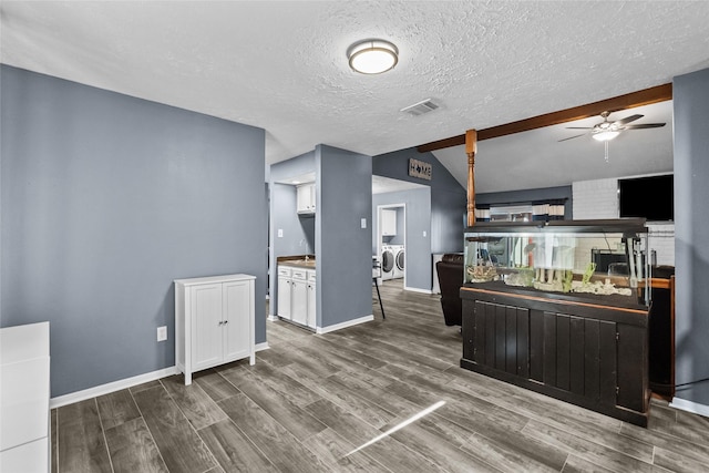 kitchen featuring a ceiling fan, wood finished floors, visible vents, and washer and dryer