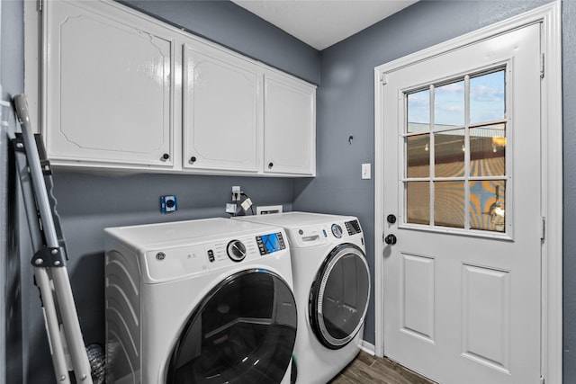 laundry room featuring cabinet space, washer and clothes dryer, and wood finished floors