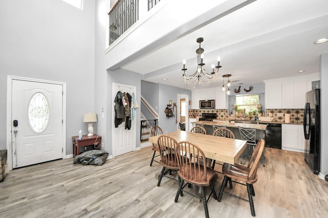 dining area featuring recessed lighting, light wood-style flooring, and an inviting chandelier