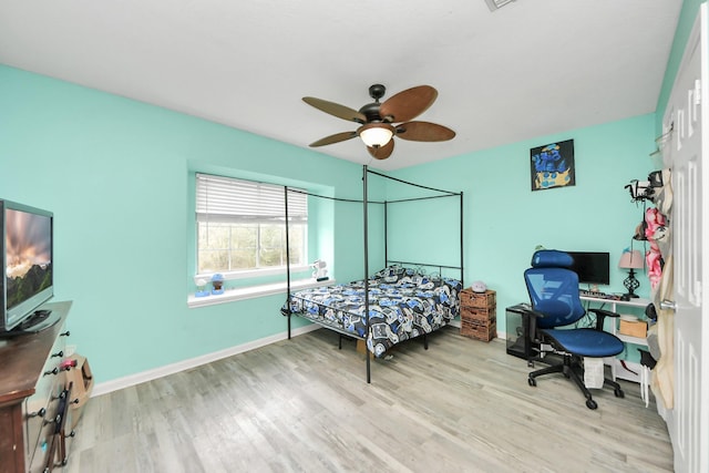 bedroom featuring a ceiling fan, baseboards, and wood finished floors