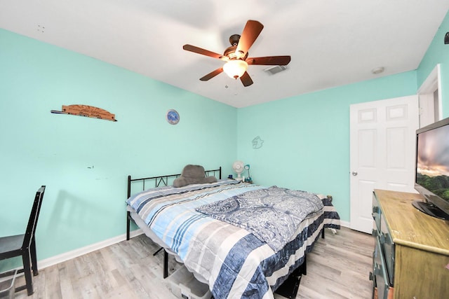 bedroom with light wood-style floors, ceiling fan, visible vents, and baseboards