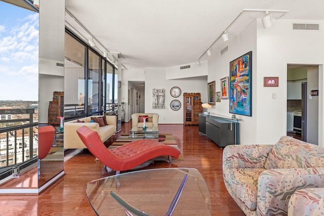 living area featuring plenty of natural light, wood finished floors, and visible vents