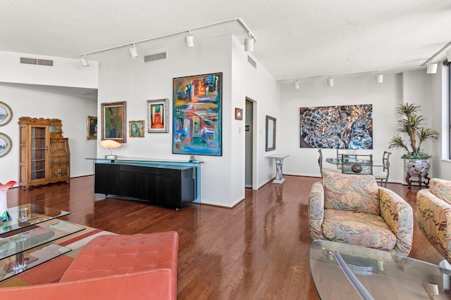 living area featuring a textured ceiling, wood finished floors, and visible vents