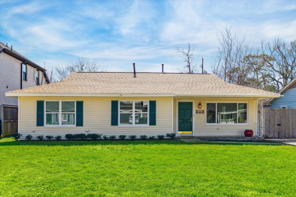 1717 Althea Dr, Houston, TX 77018 - ranch-style home with a front lawn, a shingled roof, and fence