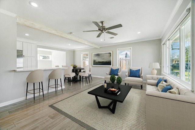 living room featuring light wood-style flooring, recessed lighting, baseboards, ornamental molding, and beam ceiling