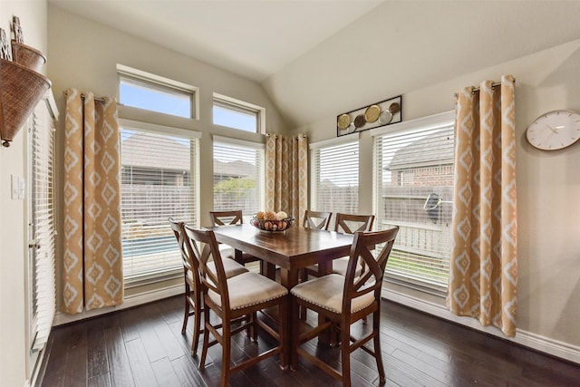 dining area featuring dark wood-style floors, vaulted ceiling, and baseboards