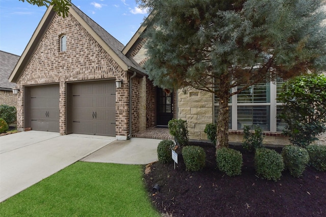 view of front facade with a shingled roof, concrete driveway, brick siding, and an attached garage