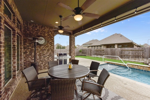 view of patio featuring a fenced in pool, outdoor dining space, a fenced backyard, and ceiling fan