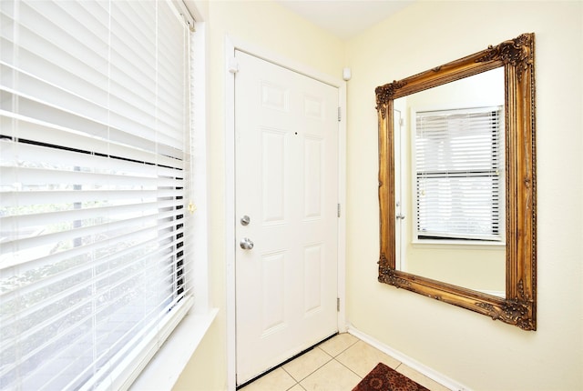 doorway to outside featuring baseboards and light tile patterned floors