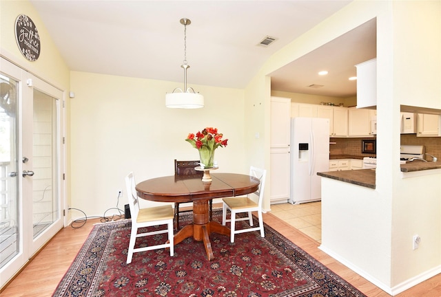 dining room featuring light wood-style flooring, visible vents, baseboards, and french doors