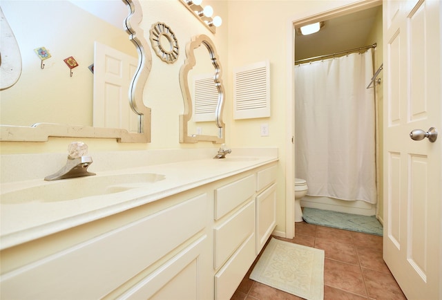 bathroom with toilet, double vanity, a sink, and tile patterned floors