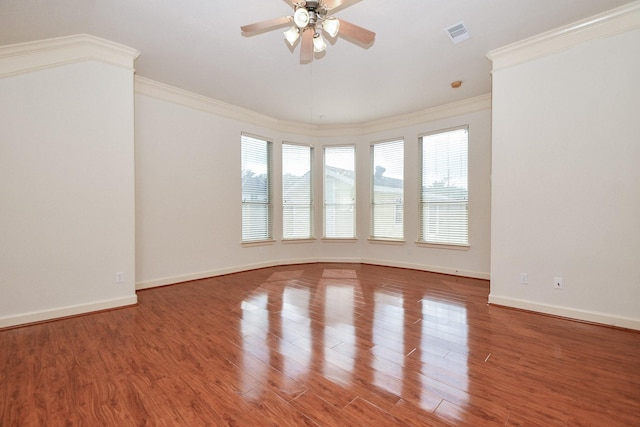 empty room featuring visible vents, a wealth of natural light, and wood finished floors