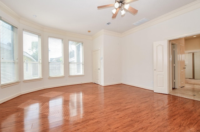 unfurnished room with crown molding, visible vents, light wood-style flooring, ceiling fan, and baseboards