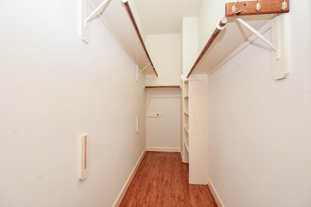 walk in closet with wood finished floors