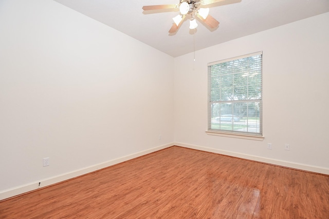 unfurnished room featuring ceiling fan, wood finished floors, and baseboards