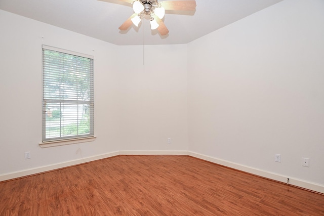 unfurnished room with a ceiling fan, baseboards, and wood finished floors