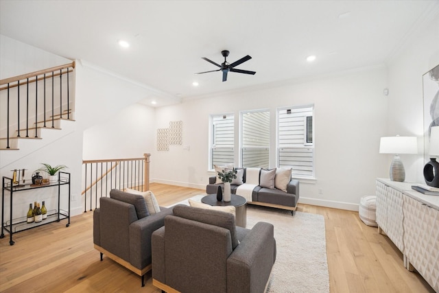 living room featuring light wood finished floors, recessed lighting, ornamental molding, a ceiling fan, and baseboards