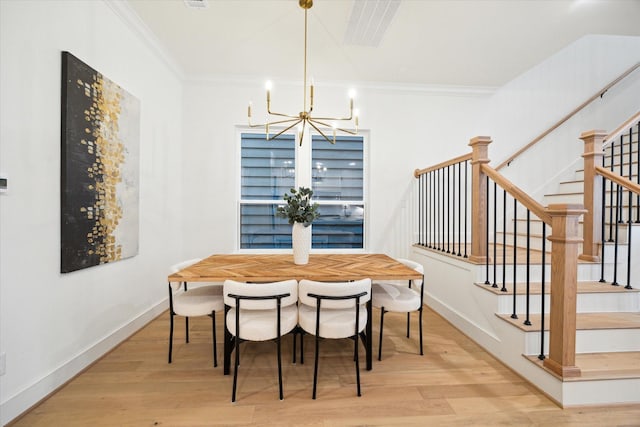 dining space with crown molding, baseboards, wood finished floors, and an inviting chandelier