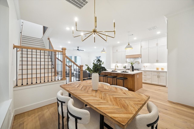 dining room with stairs, light wood finished floors, visible vents, and recessed lighting