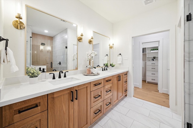 bathroom with a stall shower, visible vents, a sink, and double vanity