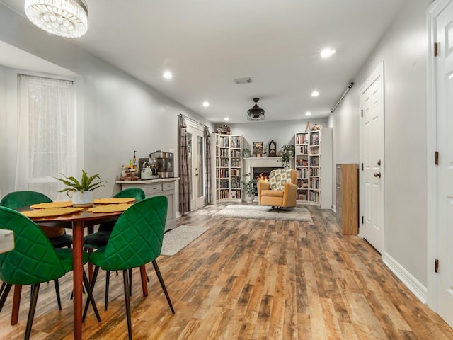 interior space with a lit fireplace, light wood finished floors, and recessed lighting